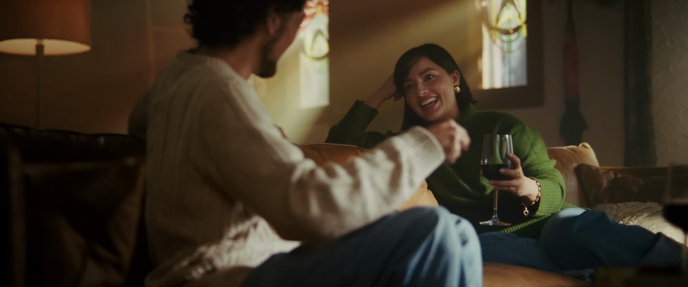 A couple talking in a warmly lit living room, from the PYXIS commercial