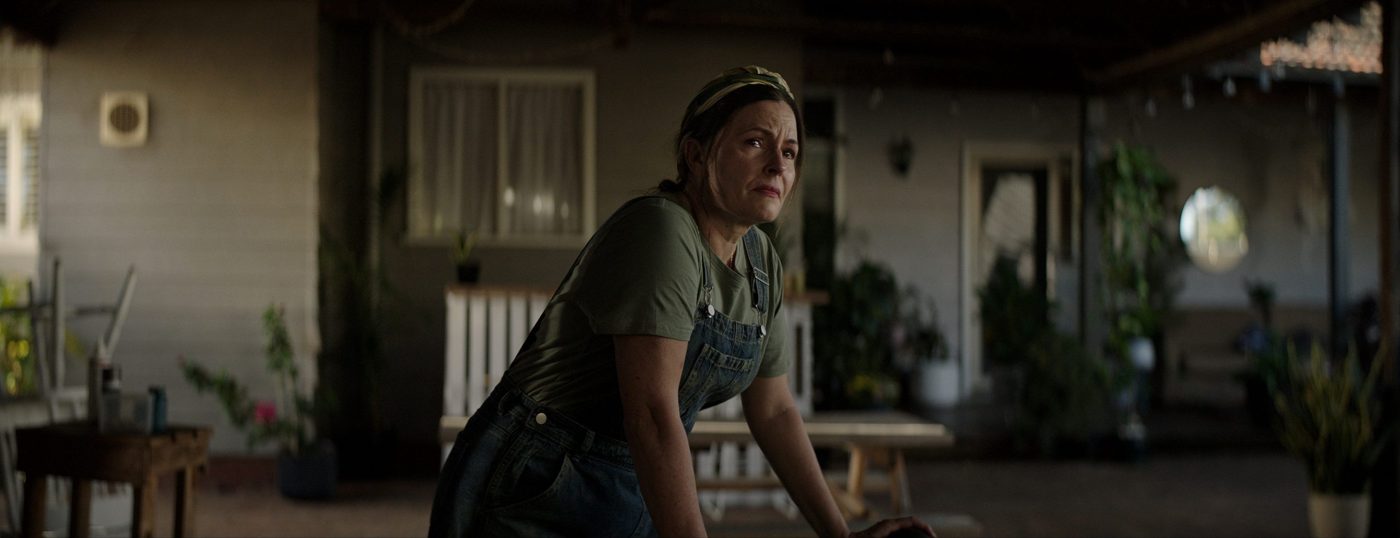 Episode #452: a mother leans on a table under a shelter, light from the open side